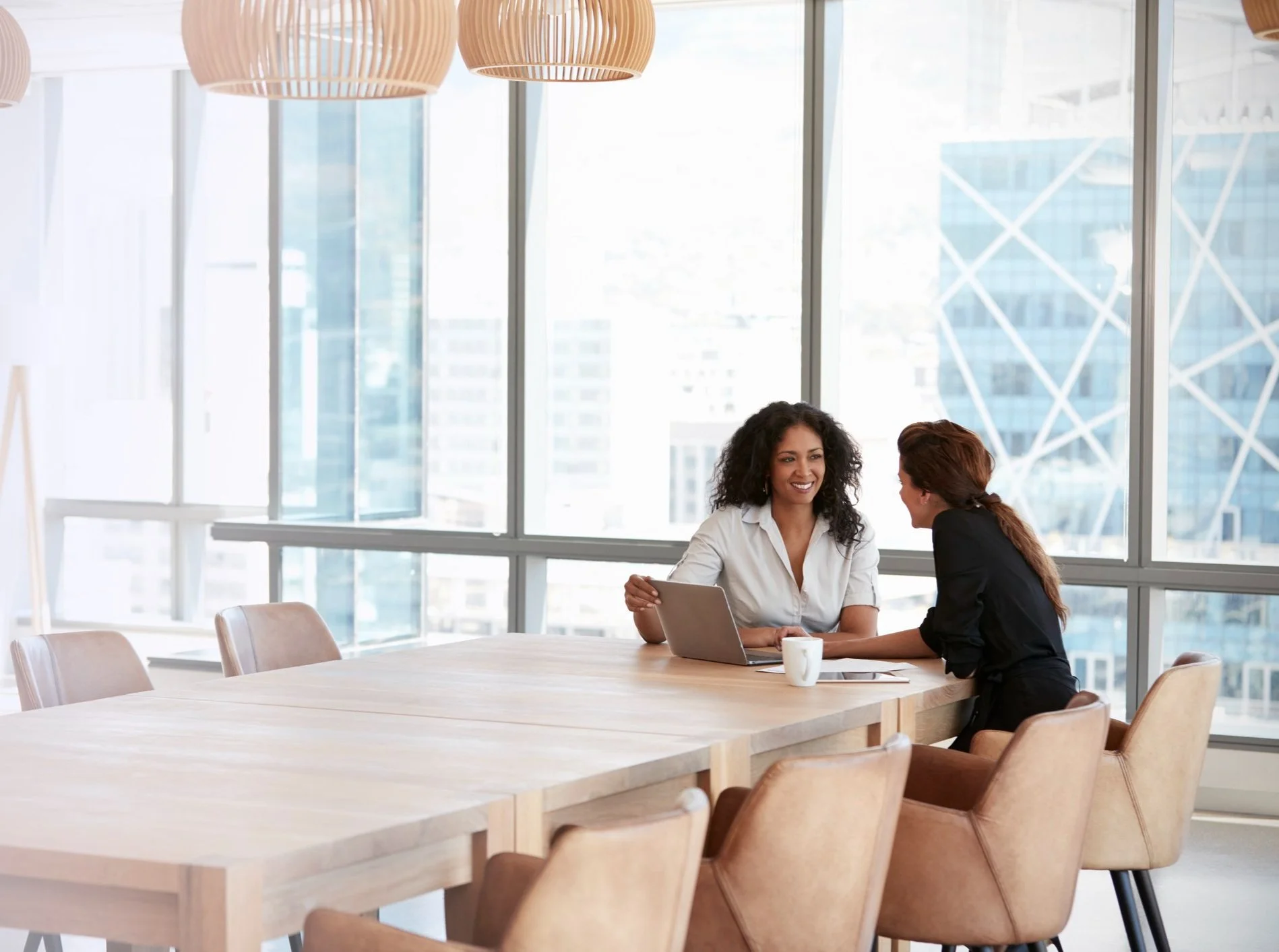 Two BTCS consultants talking with a client in a bright office